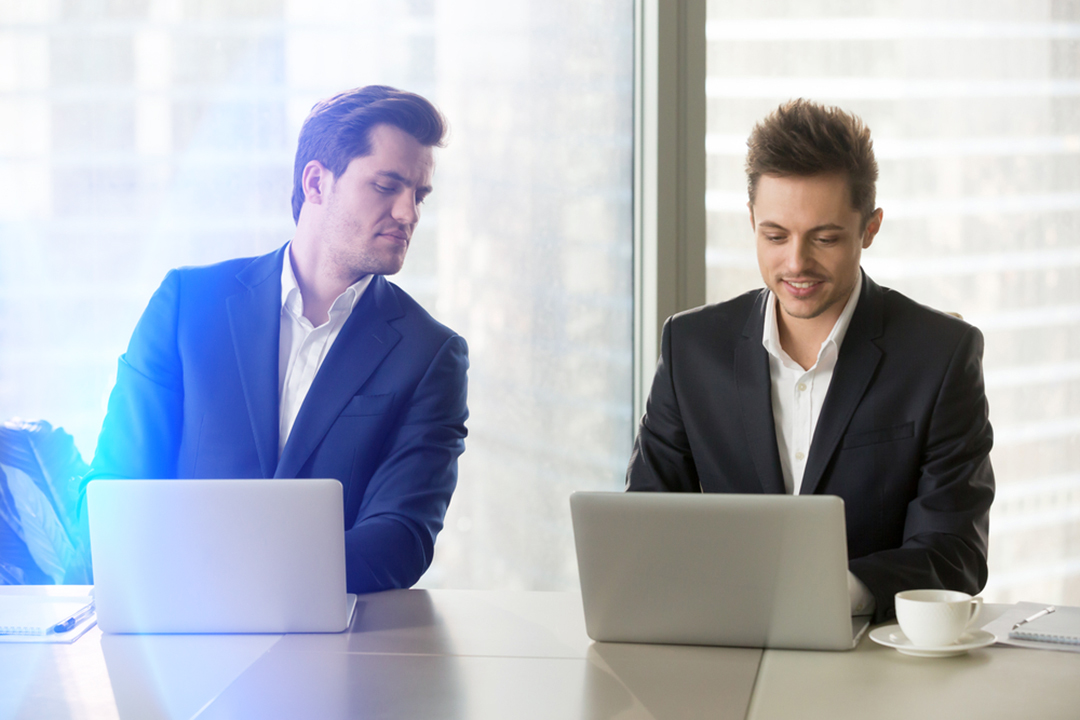 Two men working on laptop